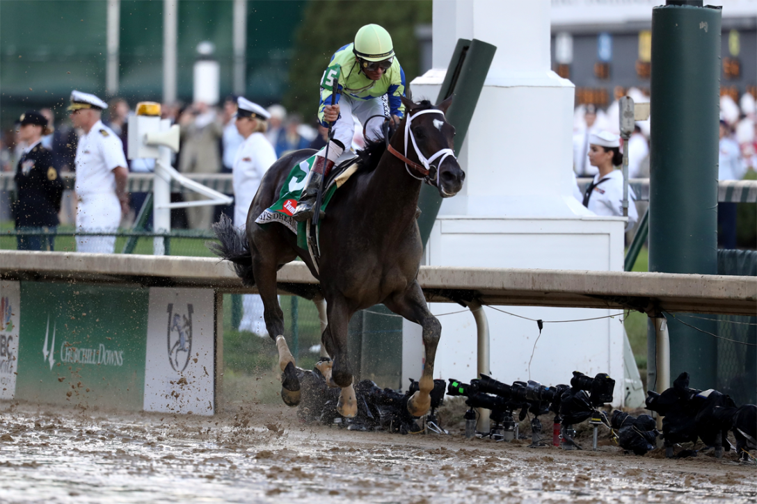 Jockey John Velazquez celebrates as he guides #5 Always Dreaming in across the finish line in the slop to win the 143rd running of the Kentucky Derby at Churchill Downs on May 6, 2017 in Louisville, Kentucky. (Rob Carr | Getty Images)